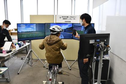 自転車シュミレーターを体験する来場者の写真