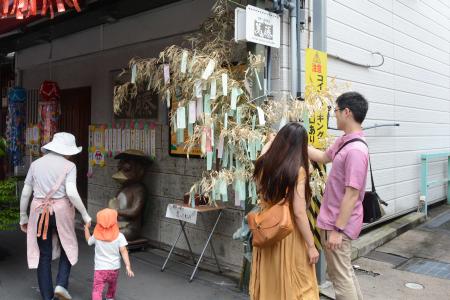 願い事を書いた短冊を笹竹につるす来場者